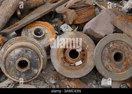 A discarded machine part lies in the gravel, rusty and marked by time - a symbol of transience, technology and industrial decay. Stock Photo