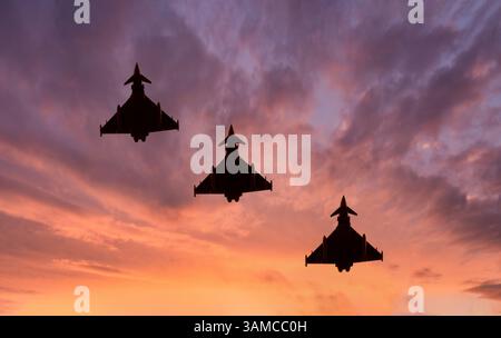 Typhoon fighter jet silhouette at sunset. Armed fighter jet flying combat missions Stock Photo