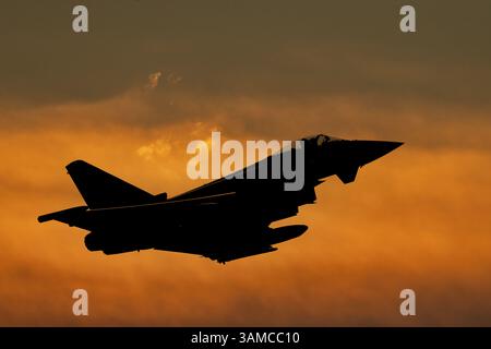 Typhoon fighter jet silhouette at sunset. Armed fighter jet flying combat missions Stock Photo