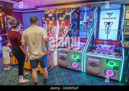 Bahamas,Norwegian Cruise Line NCL Breakaway ship 11-day Eastern Caribbean itinerary,onboard inside interior,Video Arcade,Hispanic man woman mother fat Stock Photo