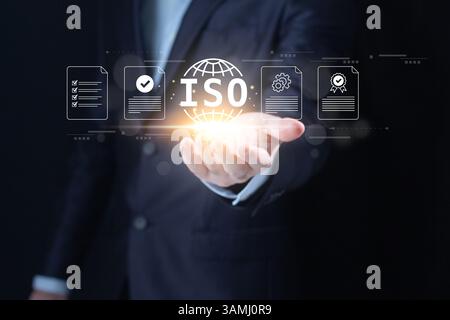 ISO Standard certification. ISO standards quality control. Businessman hold virtual globe with quality assurance or guarantee product. Stock Photo