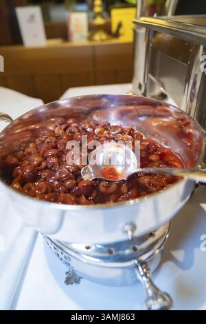 Silver bowl with red fruit and a large serving spoon on a table, Europaeischer Hof, Koenigsbach Stein, Germany, Europe Stock Photo
