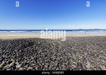 Black pebbles, volcanic rock, Playa de Famara, La Graciosa island on the horizon, La Caleta de Famara, Lanzarote, Spain, Europe Stock Photo