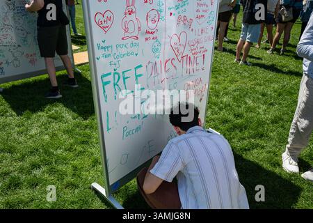 A young person writes on a white board with "Free Palestine" and other messages on it during the annual Picnic Day event on the U.C. Davis campus. Stock Photo