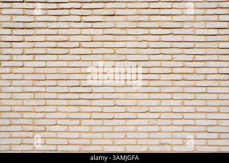 Texture of a wall of small beige bricks Stock Photo