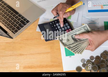 Closeup hands businessman banker counting money banknote dollars, bank financial and investment concept. Businessman using calculator, counting money Stock Photo