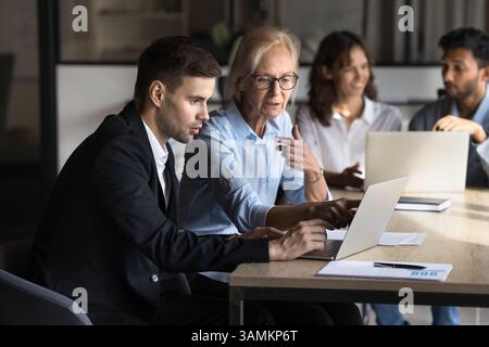 Two diverse corporate professionals teamwork with laptop Stock Photo