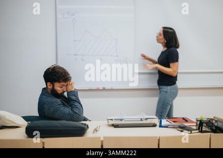 Teacher explaining mathematical concept to attentive student in classroom Stock Photo