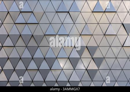 Facade of futuristic architectural wall covered with triangle patterns in varying shades of grey, abstract urban design Stock Photo