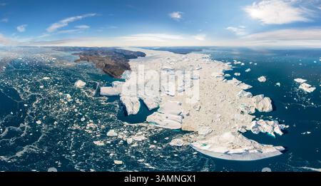 Aerial view of big glacier breaking up in Greenland during the day. Stock Photo