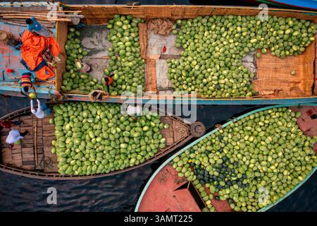 Aerial view of workers exchanging watermelons on typical boats along the Buriganga River, keraniganj, Dhaka Bangladesh. Stock Photo