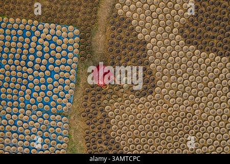 Aerial view of a woman patiently hand working with clay pots in ...