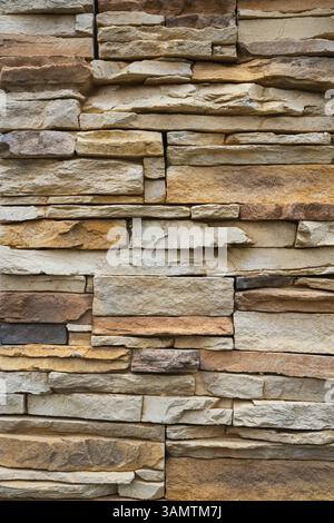 Rustic stone wall features layered texture and natural shades of brown and beige. Stock Photo