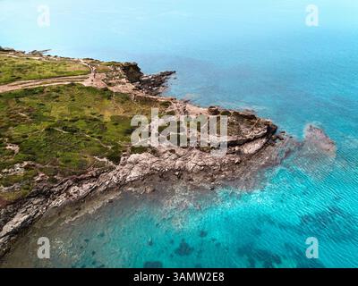 Aerial view of a spectacular cove enclosed by a cliff with an ancient watch tower from the Middle Age in Porto Ferro, Sardinia, Italy. Stock Photo