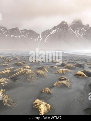 Aerial view of Vestrahorn mountain and the coastal road winding through ...