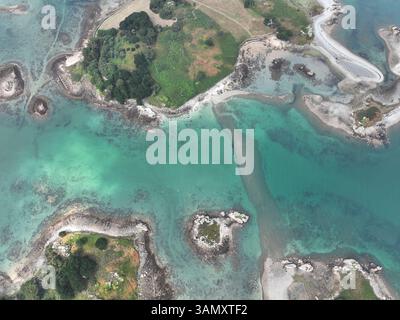 Aerial view of beautiful turquoise water and rocky coastline with greenery, Plougrescant, France. Stock Photo