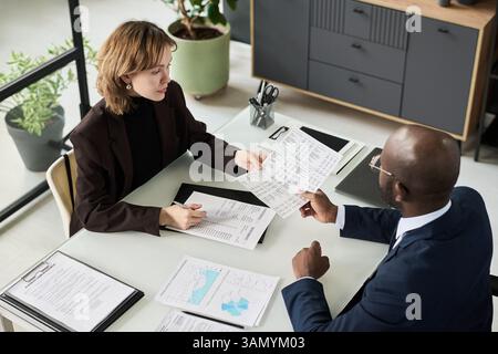 Colleagues Analyzing Financial Documents At Meeting Stock Photo