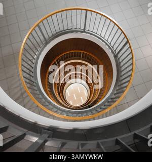 Round light well inside residential building. Looking down through round hole at lower floors inside a house. Stock Photo
