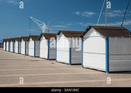 A row of blue and white painted wooden huts on Salou Marina, Catalonia, Costa Dorada, Spain Stock Photo