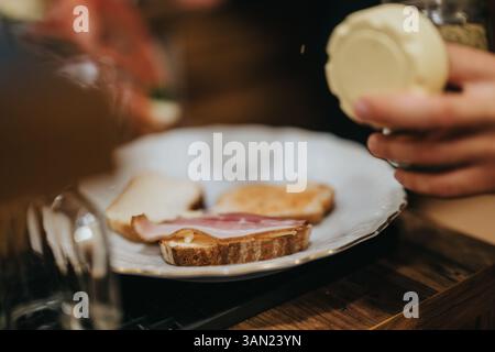 Preparing bread slices with toppings during culinary activity at a cozy kitchen setup Stock Photo