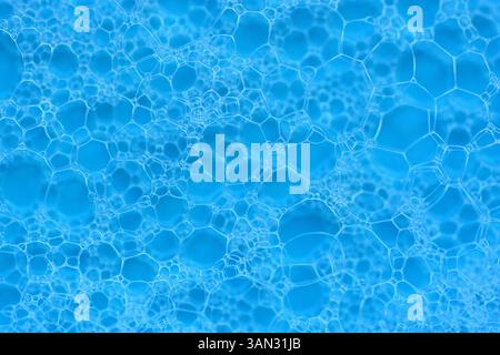 White soap bubbles abstract pattern foam texture on blue background. Stock Photo