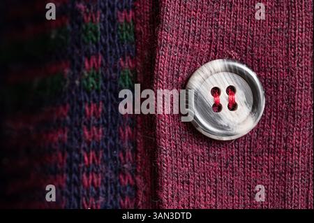 Close-up of a gray button on a red sweater Stock Photo