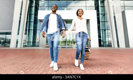 Ready For Adventures. Excited Black Couple Leaving Airport Building In ...