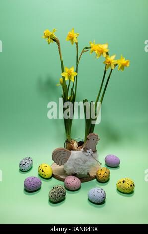 Colorful Easter decoration featuring flowers and painted eggs on a green background Stock Photo