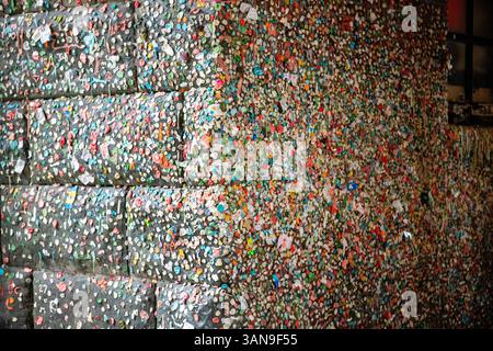 A wall covered in colorful stickers and gumballs Stock Photo