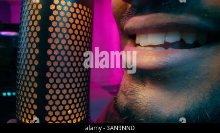 Close up streamer mouth Indian Latino man guy talking speaking microphone recording stream influencer gamer male presenter at home playing video game Stock Photo