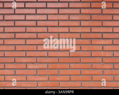 Uniform red brick wall providing a seamless backdrop for design and architectural projects Stock Photo