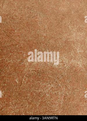 Close-up of a textured orange wall revealing unique brush strokes and imperfections, adding depth and character to the surface Stock Photo