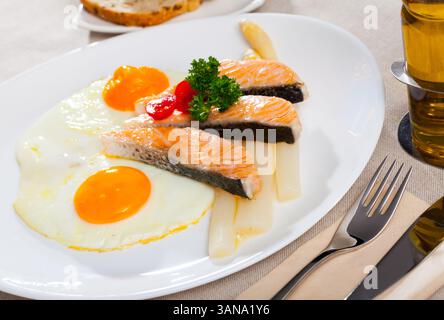 Fried salmon with scrambled eggs and asparagus Stock Photo