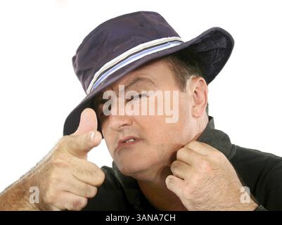 Confident man in hat looking at camera and pointing Stock Photo