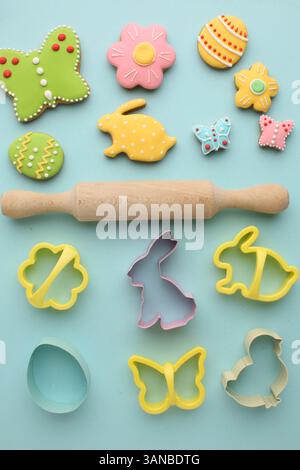 Easter biscuits and moulds for baking them on a blue background, bunny eggs and flowers, happy Easter. High quality photo Stock Photo
