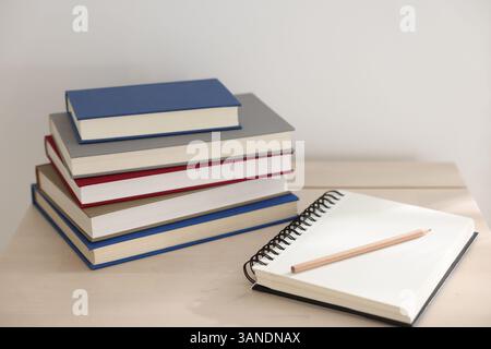 Books, notebook and pencil on wooden table indoors Stock Photo