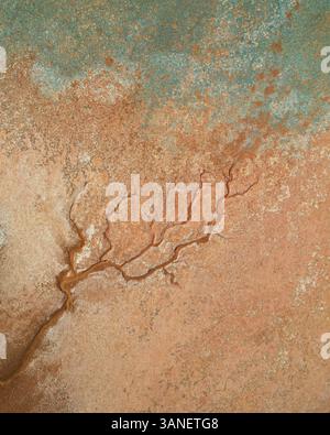 Aerial view of colorful salt pond and creek with natural patterns in rugged terrain, Onslow, Australia. Stock Photo