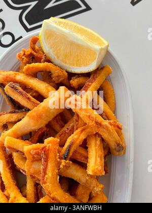 Spanish tapa of squid rabas in batter with aioli sauce tear on wooden ...