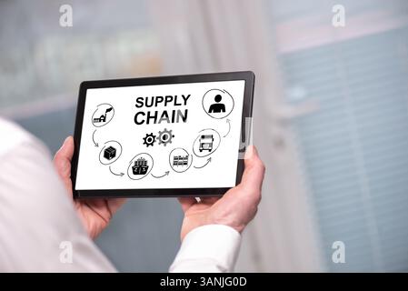Supply chain concept shown on a tablet held by a man Stock Photo