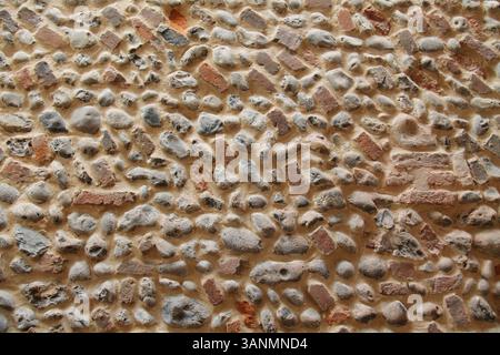 A Wall Built from Natural Flint Stones and Partial Bricks. Stock Photo