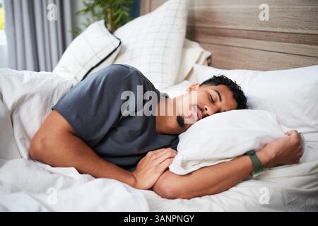 Young Man Peacefully Sleeping in a Comfortable Bed on a Quiet Morning Stock Photo