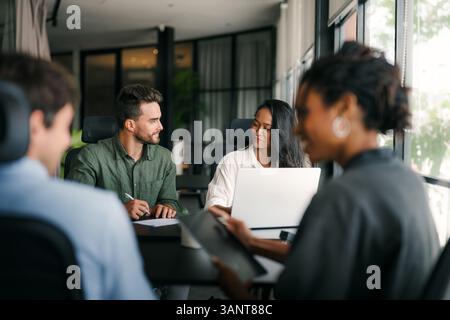 A diverse, talented team collaborates effectively in a bright office space during a business meeting Stock Photo