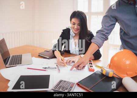 Group of two coworkers working with blueprint in office. co-working teamwork concept. Stock Photo