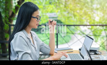 Young business woman sitting at table using laptop in coffee shop cafe. Blogging Freelancers working. Woman using laptop. Stock Photo