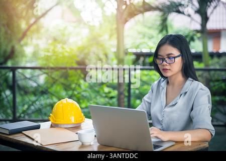 Female architect or engineer working with laptop in cafe co-working space. Stock Photo