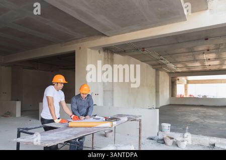 Confident team of architect working together in building construction site. They discussing about new startup project. Architect discuss with engineer Stock Photo