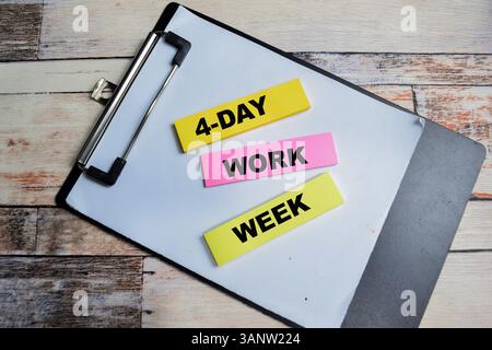 Concept of 4 Day Work Week write on sticky notes isolated on Wooden Table. Stock Photo