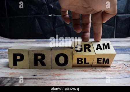 Concept word Solving a problem and making program and changes the word problem to program on wooden blocks on a wooden table Stock Photo