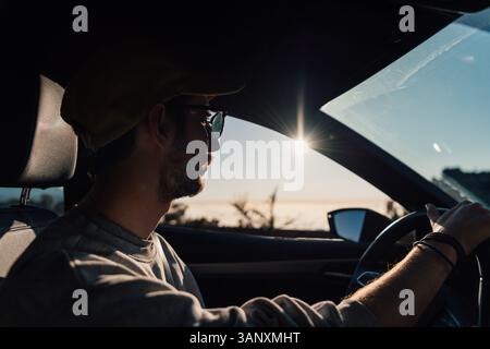 Young caucasian man driving a car at sunset in Tenerife, Canary Islands Stock Photo