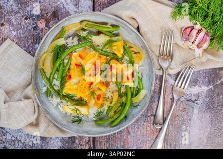 Ginger and turmeric cod with green beans and rice Stock Photo